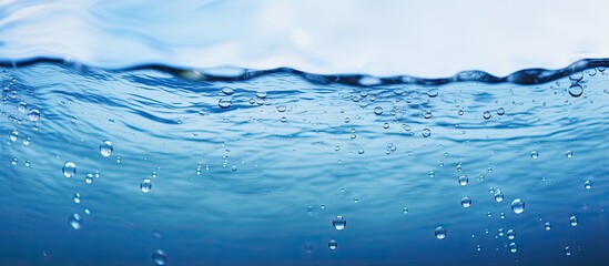 Wall Mural - Blurry blue water surface with bubbles and splashes Nature background with sunlight and space for text