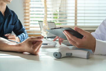 Orthopedist pointing at digital tablet, explaining treatment course, giving recovery advice  to male patient. Medical, orthopedic and health care concept.