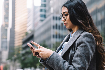 Wall Mural - Beautiful young female using smartphone outside in New York City