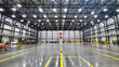 An aircraft hangar sits empty with a well lit Canadian flag in the background turned on its side