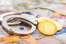 Handcuffs And Bitcoin On Various Banknotes Background.