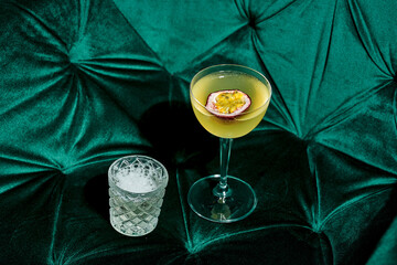 Wall Mural - Cocktail with passion fruit and foam in the bar interior. Photo for the menu