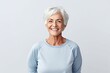 Happy senior woman looking at camera. Cheerful senior woman smiling and looking at camera while standing against grey background
