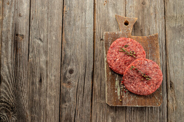 Poster - Fresh raw meat cutlets on a wooden background, Long banner format. top view