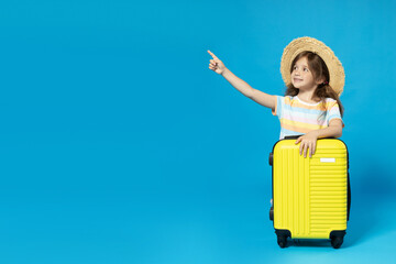 Wall Mural - A little girl in a beach hat with a suitcase