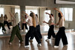 team of young female dancers practice choreography in the studio in front of the mirror