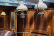 Historic wood paneled lounge, bar or dining room onboard nostalgic windjammer sailing yacht boat with brass oil lamps, table and coucher as well as cabin doors