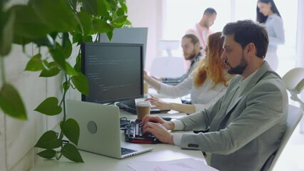 Male IT Programmer Working on Desktop Computer. Guy Writing Code in Terminal.