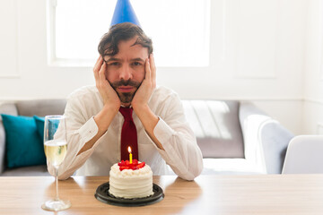 Sad caucasian man celebrating his birthday alone