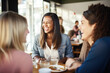 © Jasmina - Happy smiling female friends sitting in a café laughing and talking during a lunch break