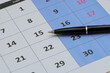 Kalendarz i długopis wskazujący na 15 dzień miesiąca 