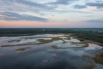 Wall Mural - Aerial view on Braslav lake  Snudy, Belarus. Summer sunset on lake Snudy, small islands on lake of dry reed. The sky is reflected from the surface of the lake water.