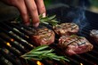 hand placing a rosemary sprig on grilled steaks