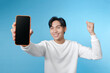 © makistock - Asian handsome young, holding a big giant huge smart phone screen mockup to show the app,