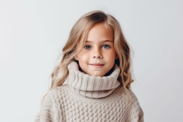 Wall Mural - Portrait of a cute little girl with blond hair in a warm sweater on a white background