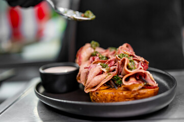 Wall Mural - chef Cooking of beef tongue with potatoes and mushroom sauce at the restaurant kitchen