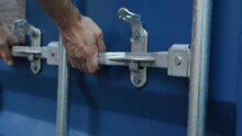 Close up view on man hands is opening the lock of large shipping container doors