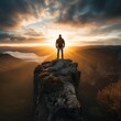 Man silhouette stay on sharp rock peak the view of sunset over an autumn forest in deep velly bellow. Enjoy the moment freedom