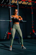 © Guys Who Shoot - beautiful young fitness woman trainer doing exercises with dumbbells in hands pumping up muscles in gym training for bodybuilding competition