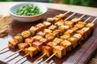 skewers with cubed marinated tofu laid on bamboo mat