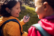 © Marko Geber - Young hikers using a compass to navigate through the forest