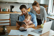 © Geber86 - Young family using the tablet together in the kitchen