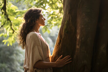 Woman connecting with the nature embracing a tree
