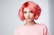 A fashionable young woman with a stylish pink wig and glamorous makeup, posing in a studio.