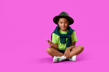 Poster - African-American little boy with mobile phone sitting on purple background