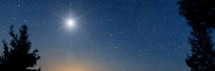 Wall Mural - Christmas star shines at night over the mountains of Bethlehem