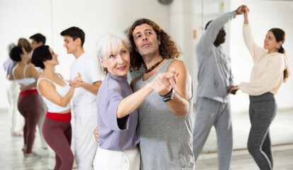 Wall Mural - Caucasian man and mature woman rehearsing latin paired dance moves