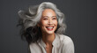 Beautiful aging and mature Asian woman with flawless skin. Flowing grey hair. Healthy smile