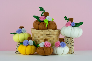 Wall Mural - Handmade cute pumpkins made from felt on pink background