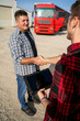 © phoenix021 - Unrecognizable Truck driver shaking hands with fleet manager , truck blurred in background