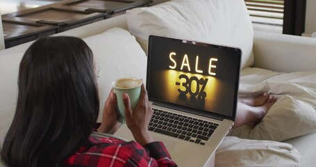 Poster - Biracial woman using laptop at home for online shopping, slow motion