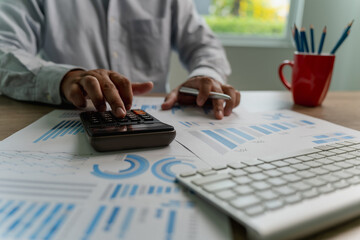 Wall Mural - man using a calculator accountant working on desk budget and loan Close up Accounting analysis, tax finance, bank income savings budget