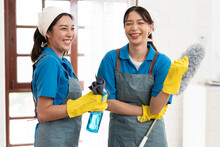 Portrait two Asia woman in workwear maid cleaning home and holding dusting brush and microfiber cloth in her hand at home	