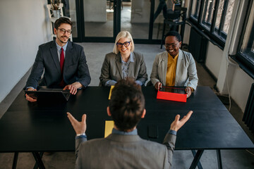 Wall Mural - Diverse group of business professionals engaged in a productive meeting in a modern office setting, seated around a sleek conference table