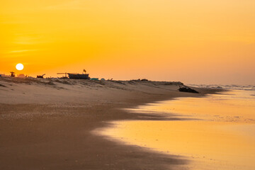 Wall Mural - Sun rising on the beach with beautiful light wooden boats, wonderful scenery in Ho Coc