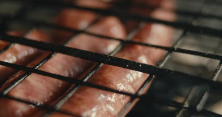 Sausage meat on a grill barbeque net tasty food smoke macro close up