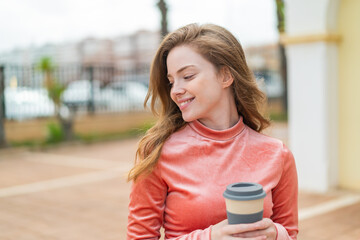 Sticker - Young redhead woman at outdoors holding a take away coffee