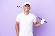 Young caucasian man isolated on purple background playing golf