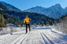 Woman Skiing On Snowy Landscape In Front Of Karwendel Mountains