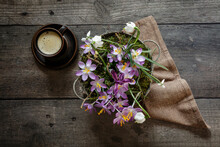 Cup Of Coffee And Springtime Flowers In Metal Bucket Standing On Wooden Table
