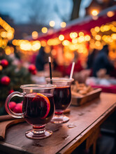 Close Up Of Red Mulled Wine On A Table, Blurred Christmas Market With People In Background