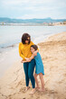 © Westend61 - Smiling girl hugging mother in front of sea on coastline at beach