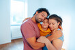 © Westend61 - Man and woman embracing daughter at home