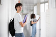 © Westend61 - Happy student holding file folder in corridor