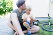 © Westend61 - Father kissing and caring son fallen down from bicycle at footpath