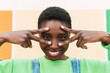 © Westend61 - Happy woman showing peace sign gesture and touching face
